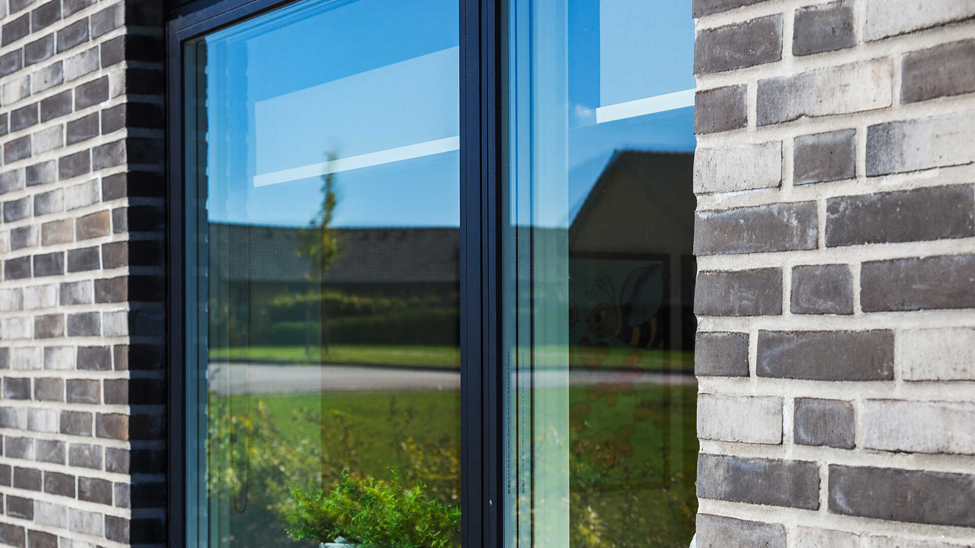 Skiffer på sålbænke ved sort vinduesparti.